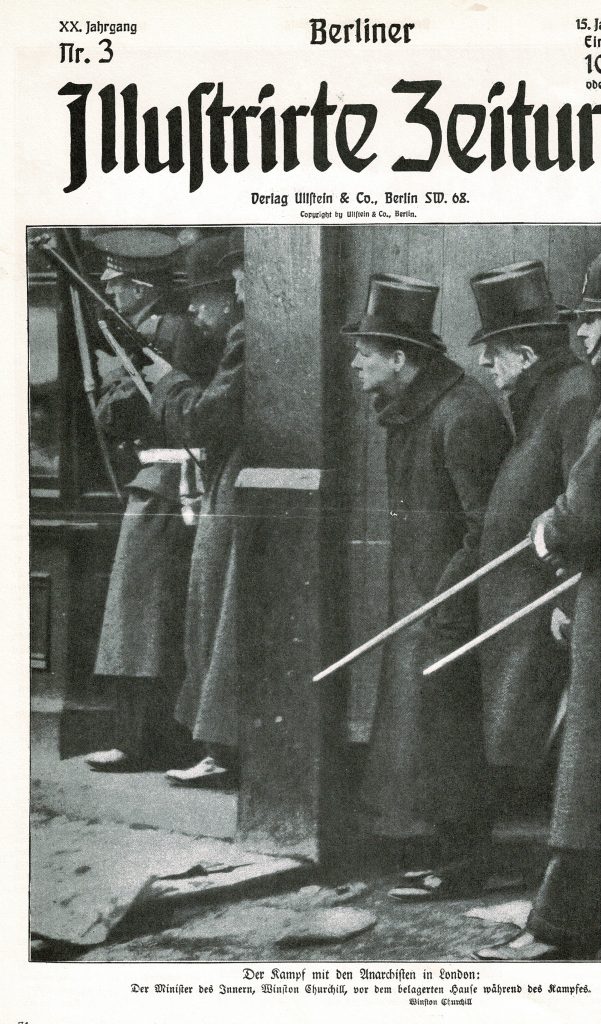 Innenminister Churchill, umringt von Soldaten blickt um die Ecke eines Hauses